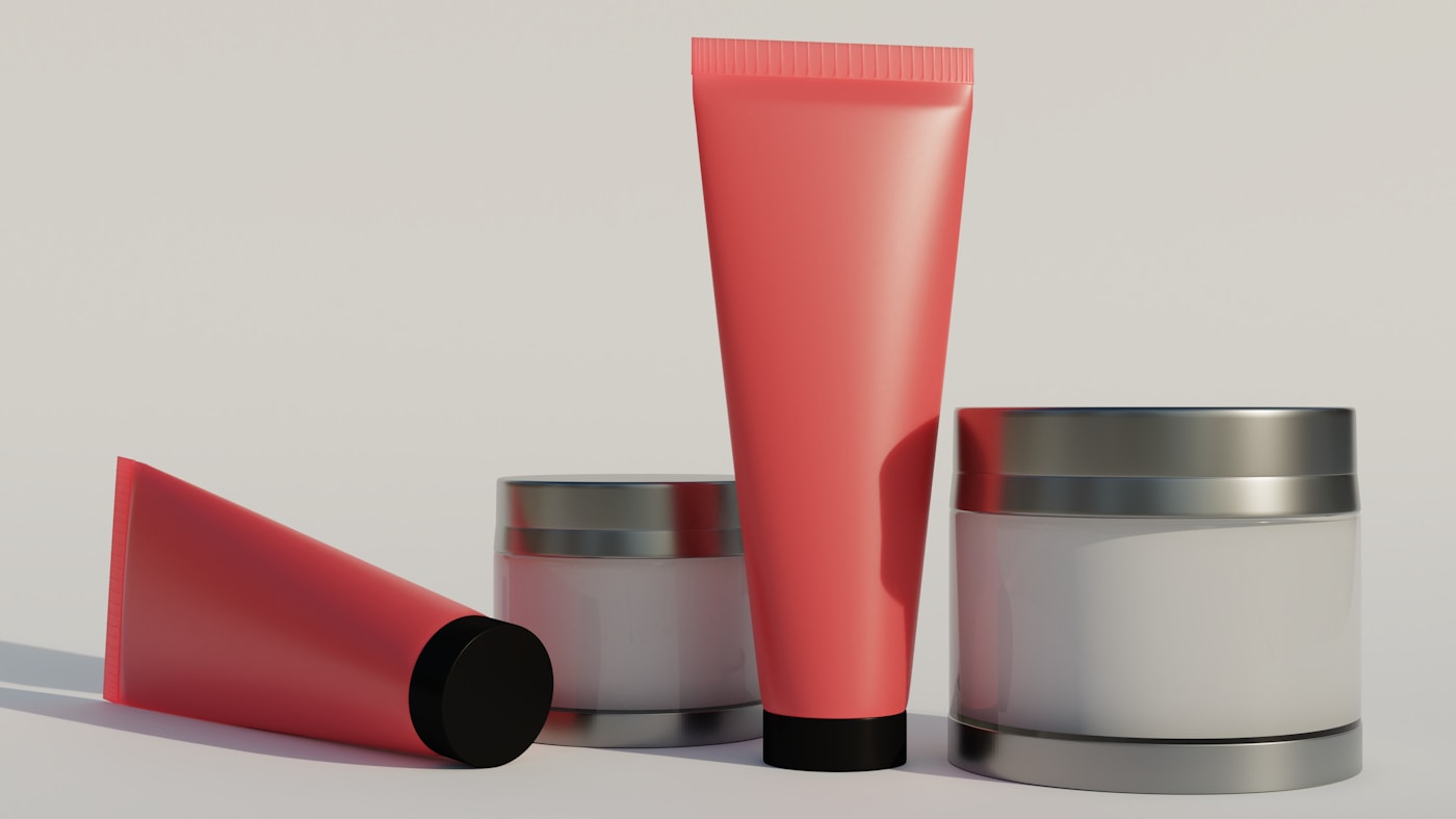 A pink tube next to two white containers